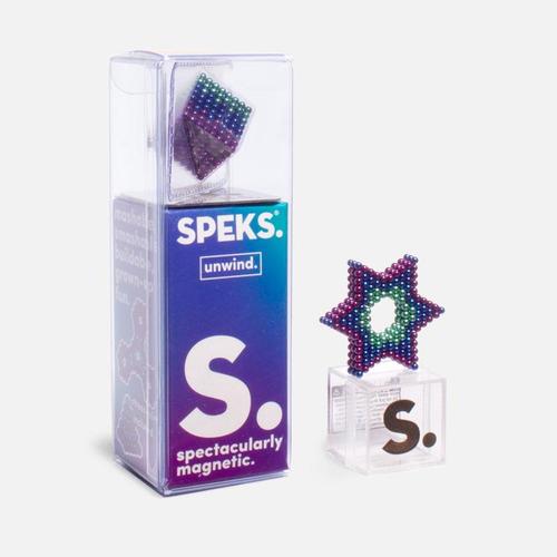 box packaging of specks with words "spectacularly magnetic" on it and a star shape made from green, blue, and purple magnetic balls on a small acrylic stand on a white background.