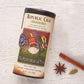 republic chai black tea canister displayed next to star anise and cinnamon stick on a white wooden surface