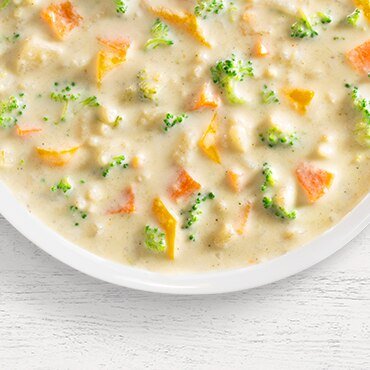 a bowl of virginia blue ridge broccoli cheddar soup on a white background