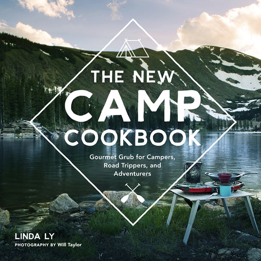 cover of book with image of a lake and mountains in the background and a camp table with stove and pans in the foreground.