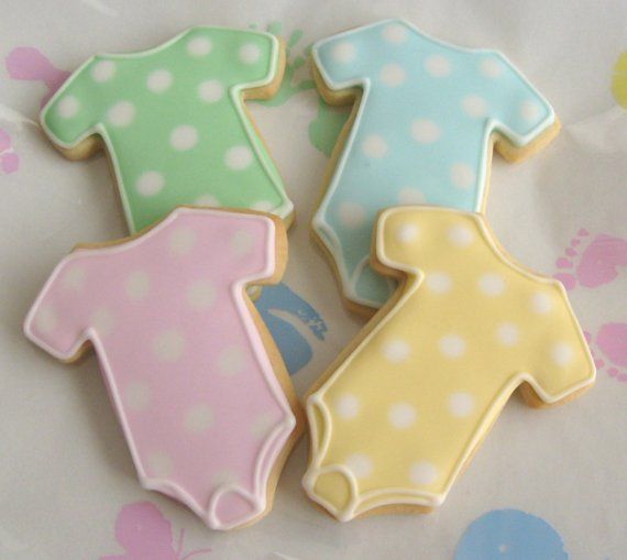 onesie shaped cookies decorated with pastel colors and dots.