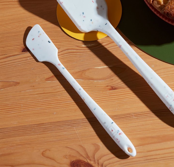 the barcelona mini spatula displayed on a wood table beside a pie