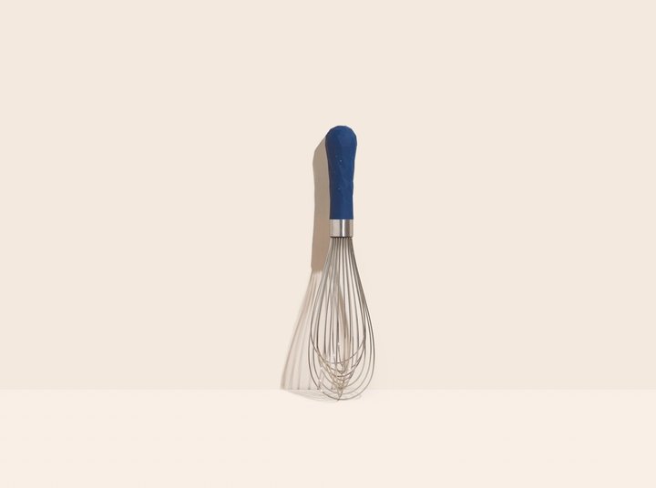 starry night ultimate whisk handle is navy blue and displayed on a light pink background