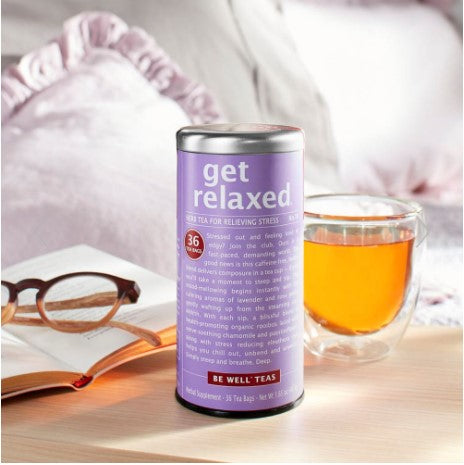 get relaxed red tea canister displayed next to a glass of tea, book and glasses