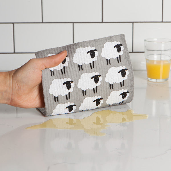 hand using swedish dishcloth to wipe spill off counter.