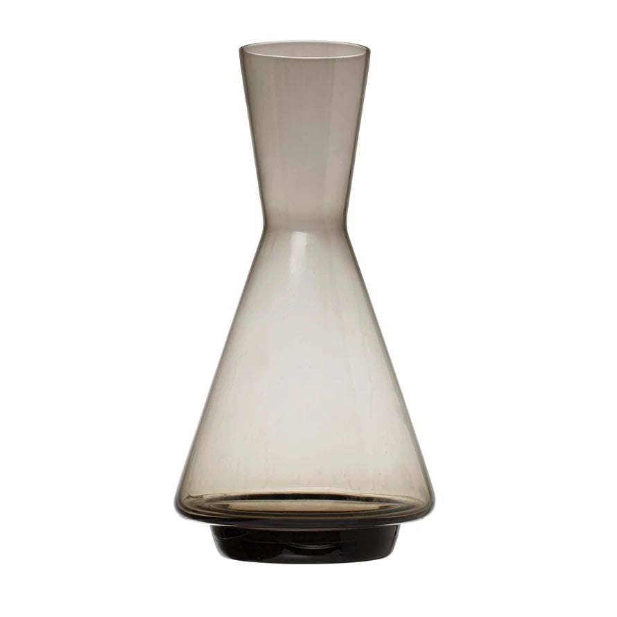 grey glass decanter with wide bottom and narrow neck on a white background.