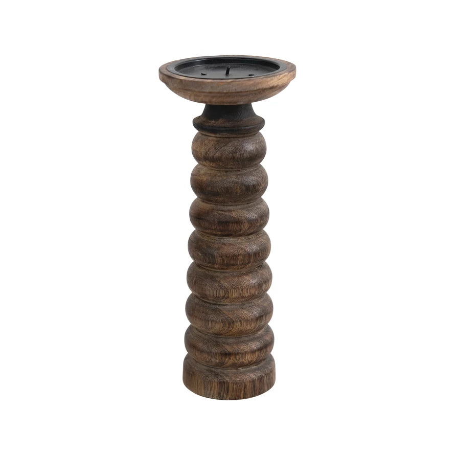 tall dark wooden candle stick with carved rings on a white background.