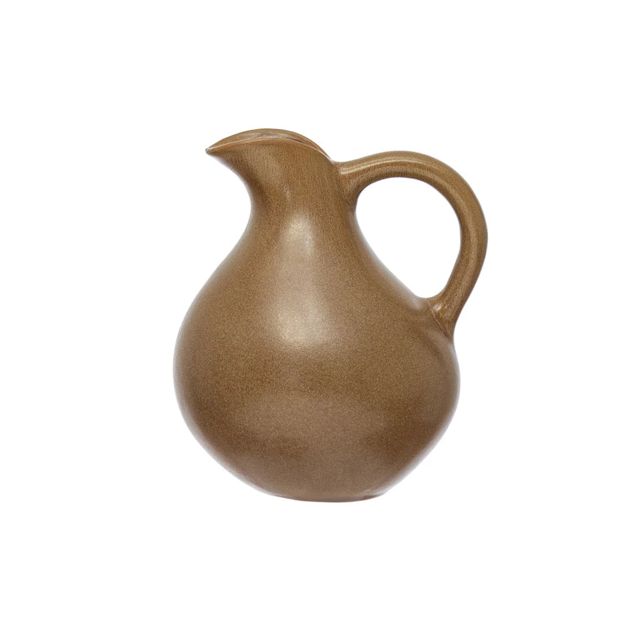stoneware pitcher with rounded handle on a white background