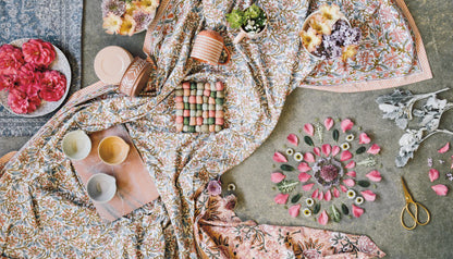 arrangment of textiles, mugs, florals, and wool trivets.