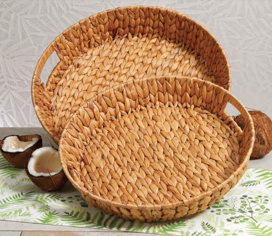 2 sizes of round woven hyacinth baskets arranged on a table  with a leaf design table runner and coconut halves.