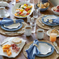 table display with dinner plates, salad plates, chargers and cups on a wood table