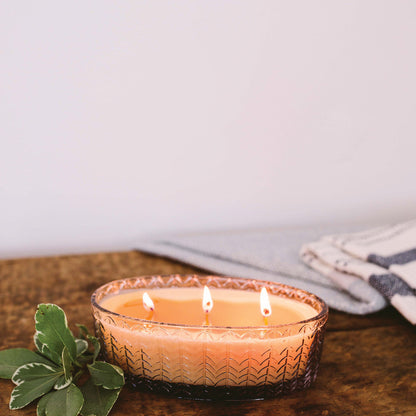 sweet grace candle on a rustic wood table against a white background