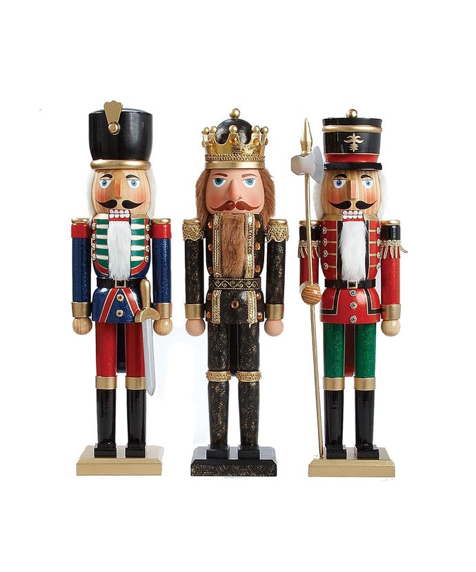 3 wooden nutcrackers with fair skin tones, one king wearing black coat and pants with gold trim and a gold crown, one soldier wearing blue coat, red pants, black hat, and holding a sword, another soldier wearing red coat, green pants, black hat, and holding an axe.