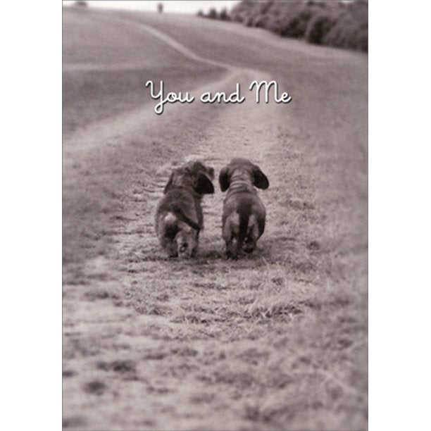 front of card has a black and white picture of two dachshunds walking away down a path and text in white "you and me" 