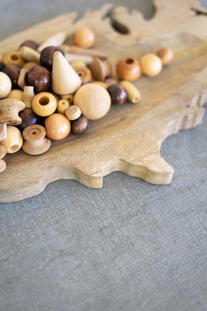 close up view of the carved wood usa platter displayed with wood knobs on a light gray surface