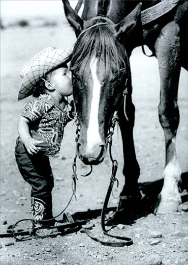 front of card is a photograph of a little cowgirl kissing a horse