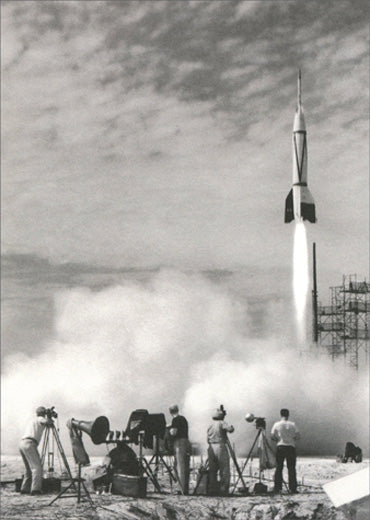 front of card is a black and white photograph of the launching of a rocket and people in the foreground taking pictures
