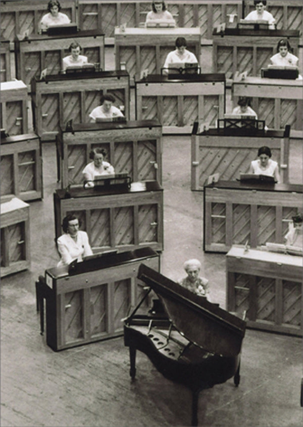 front of card is a photograph of a room full of pianos with woman playing them
