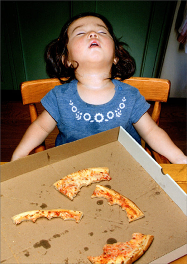 front of card is a photograph of a little girl sleeping after eating pizza