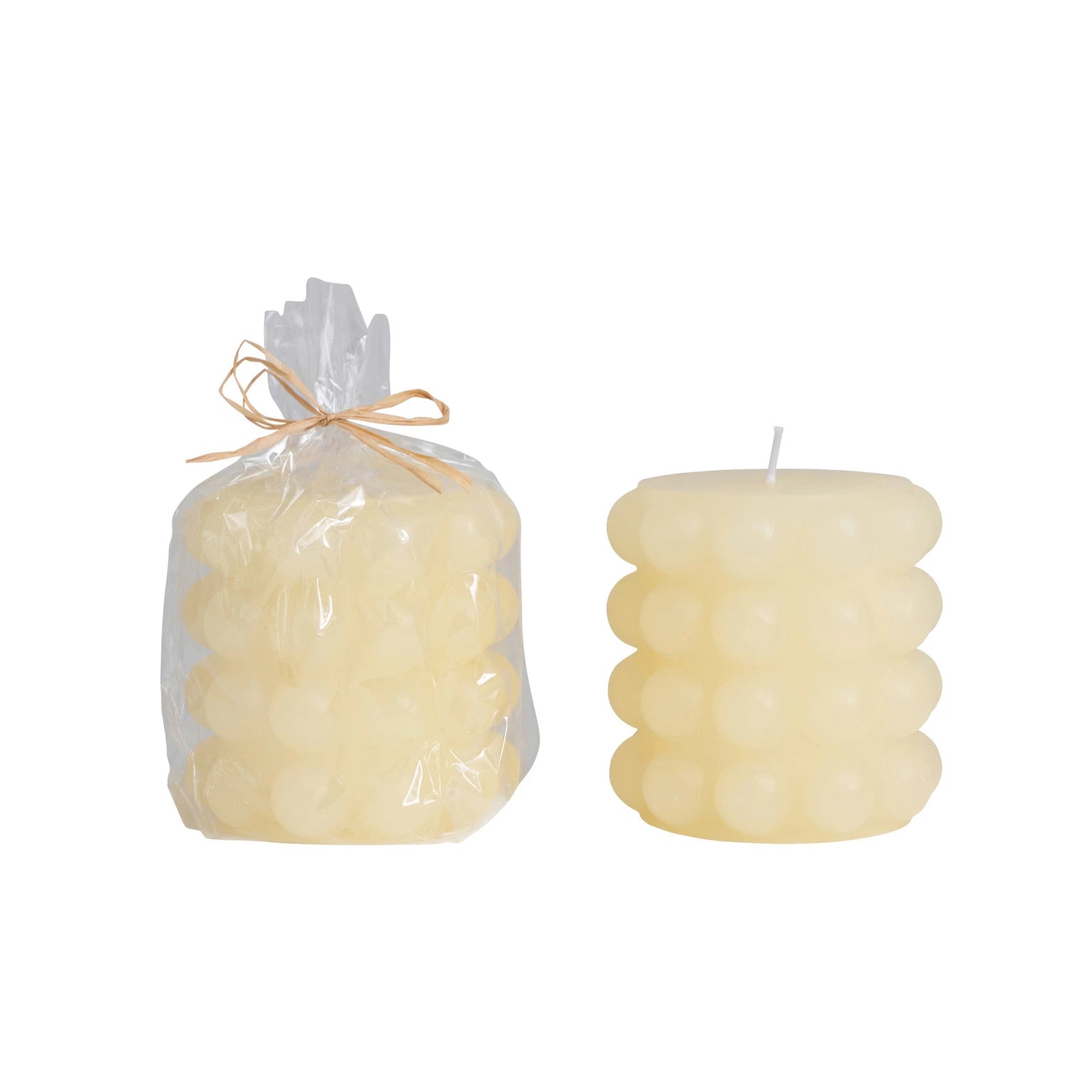 one small cream hobnail pillar candle in clear wrap with twine bow and one without the package on a white background