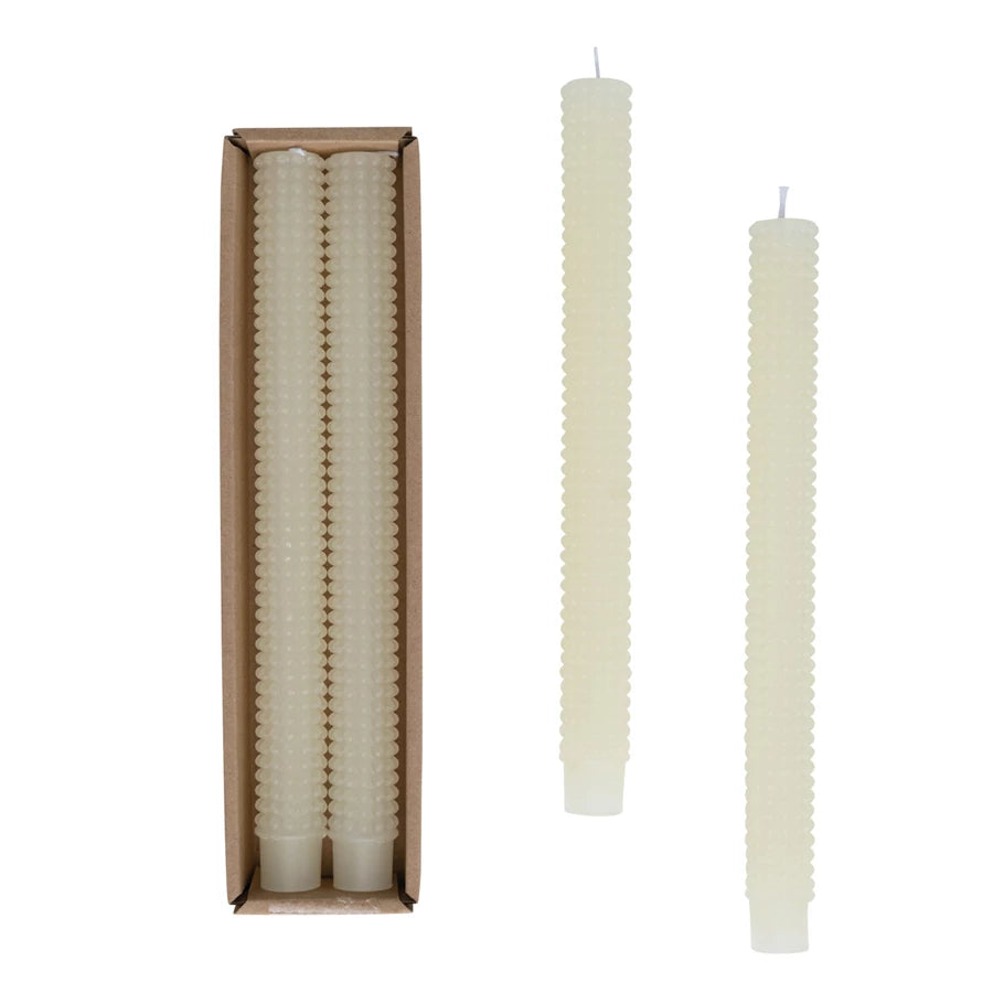 one set of hobnail taper candles in the packaging and two displayed next to it on a white background