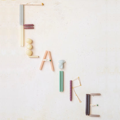 the word "flaire" spelled out in different color and shaped candles on a white background