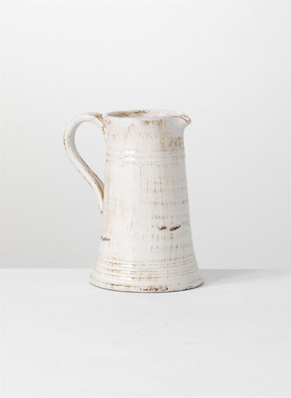 glazed ceramic pitcher on a light gray surface