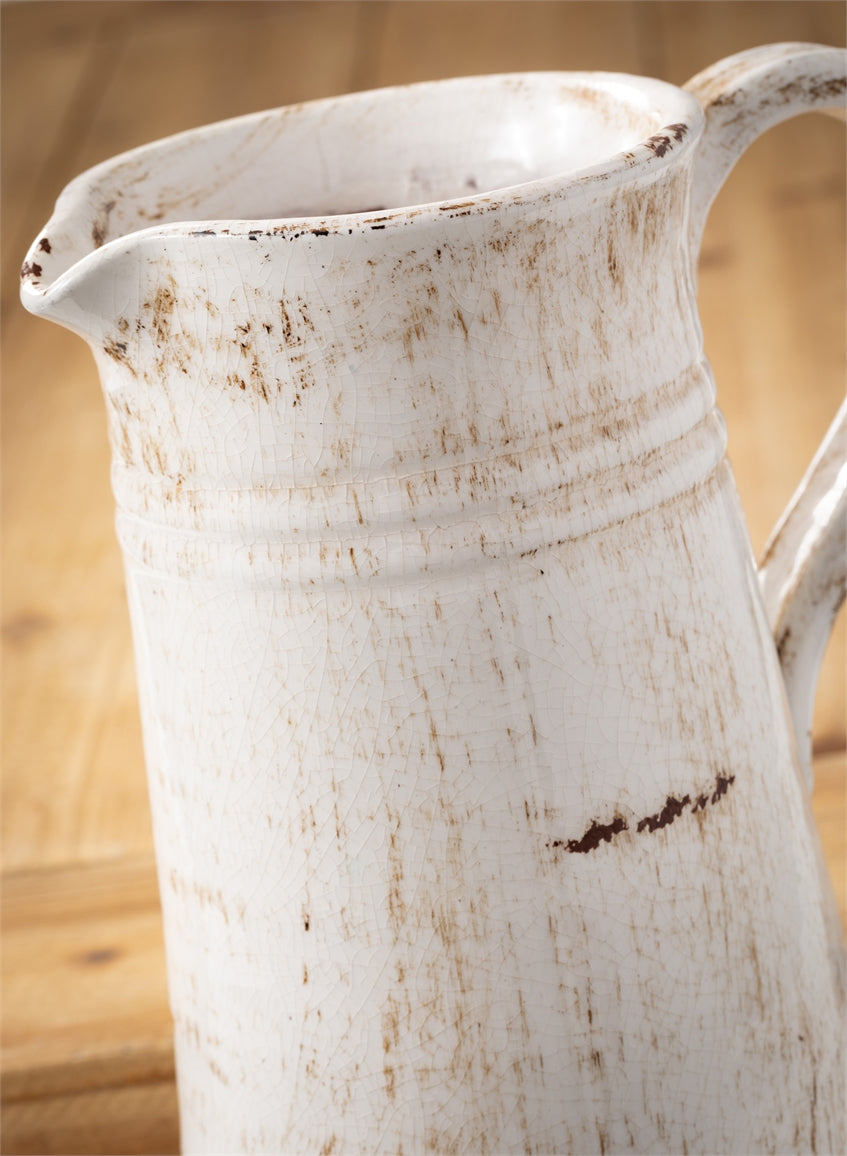 close up view of the glazed ceramic pitcher on a wooden surface