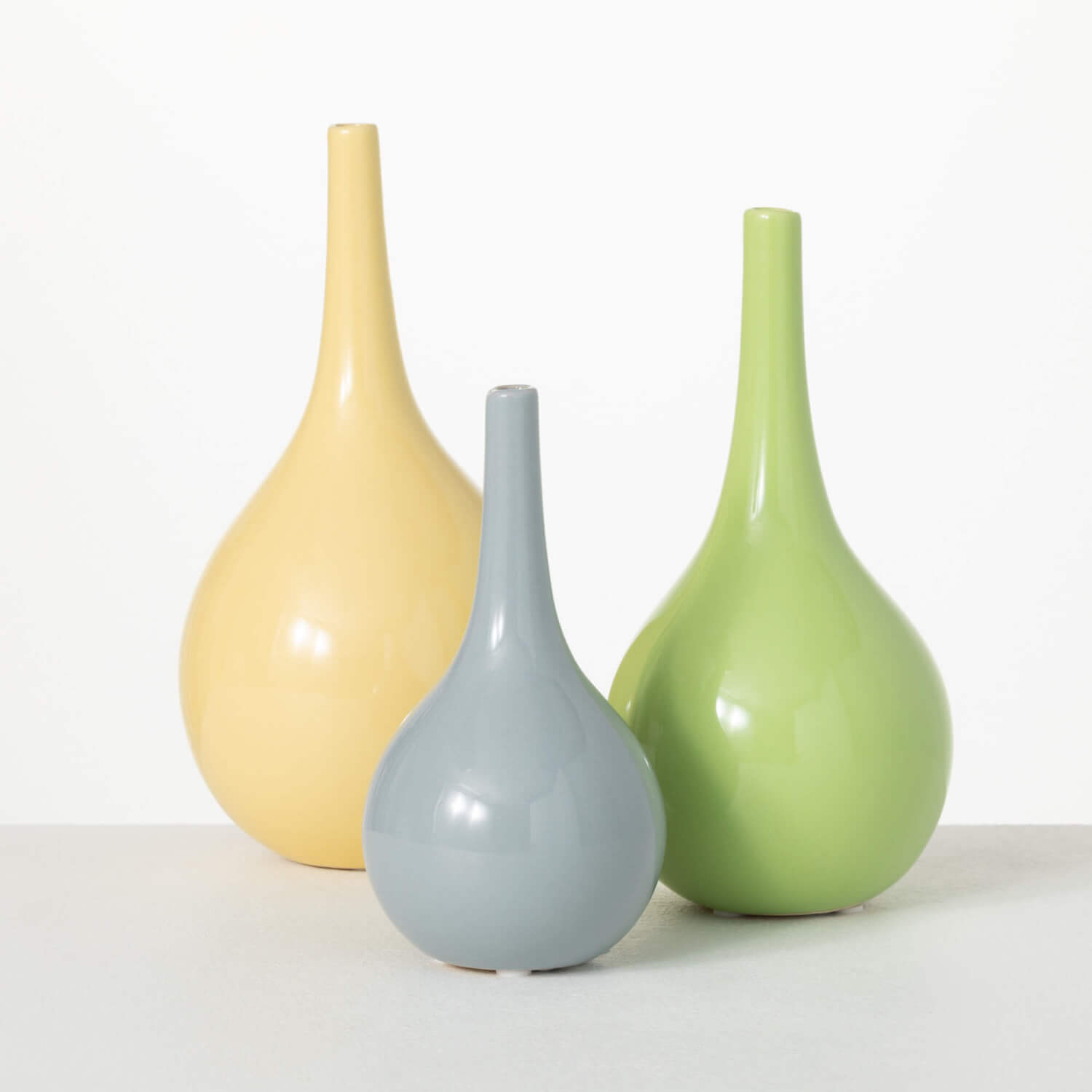 all three colors of bright glossy vases displayed against a white background