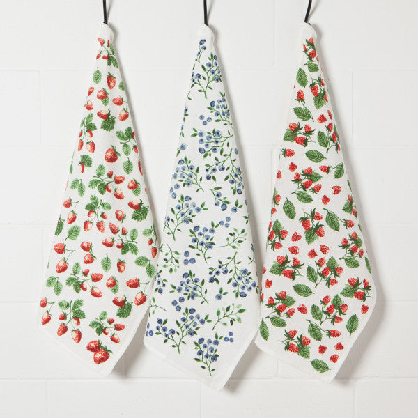 3 berry printed towels hanging on hooks.