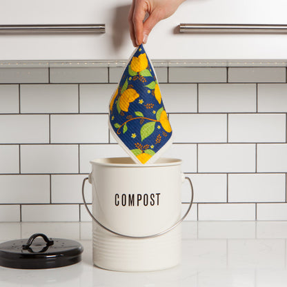 hand holding swedish dish cloth above compost pail.