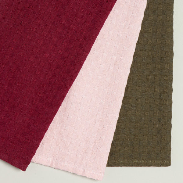 3 waffle weave dish cloths, one each of maroon, pink, and olive green.