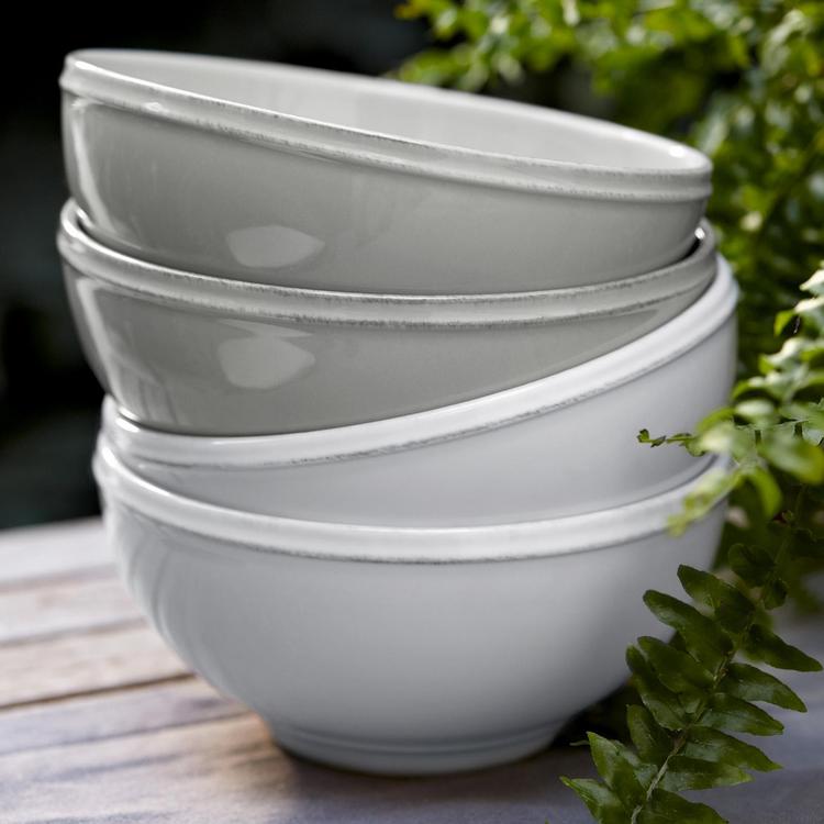 stack of 2 white and 2 grey cereal bowls and greenery.