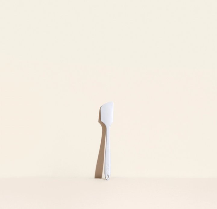 mini spatula leaning against a cream colored background.