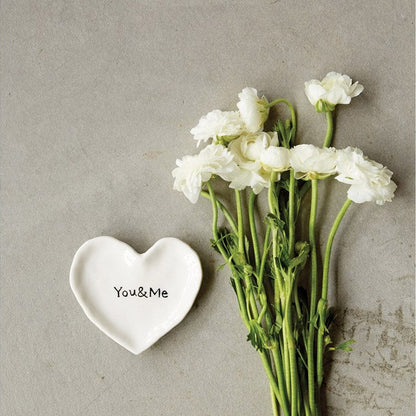 you and me heart plate displayed next to a bundle of flowers on a gray background