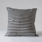 black and white striped pillow on a light gray background