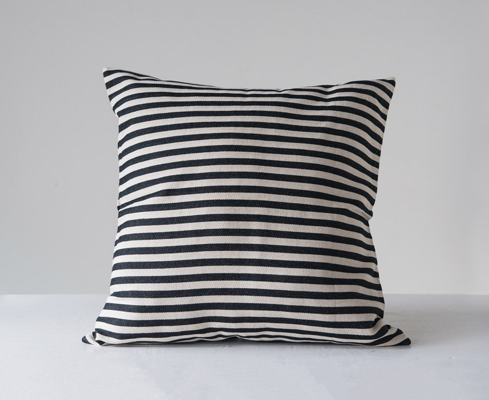 black and white striped pillow on a light gray background