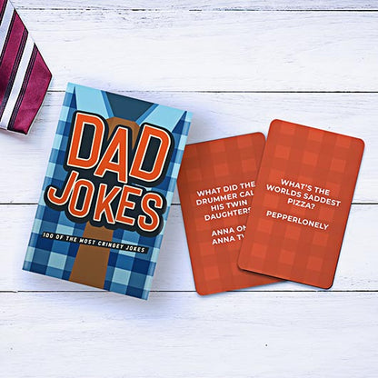 the dad jokes package and cards displayed on a white slat table 