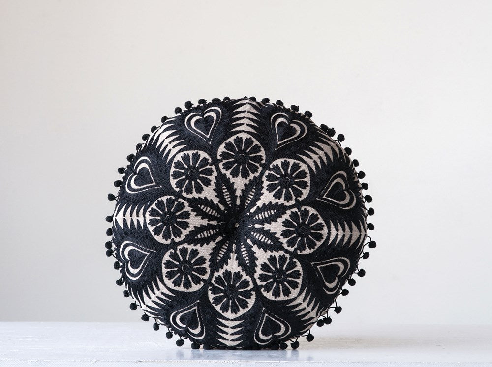 black and white embroidered pillow on a white background