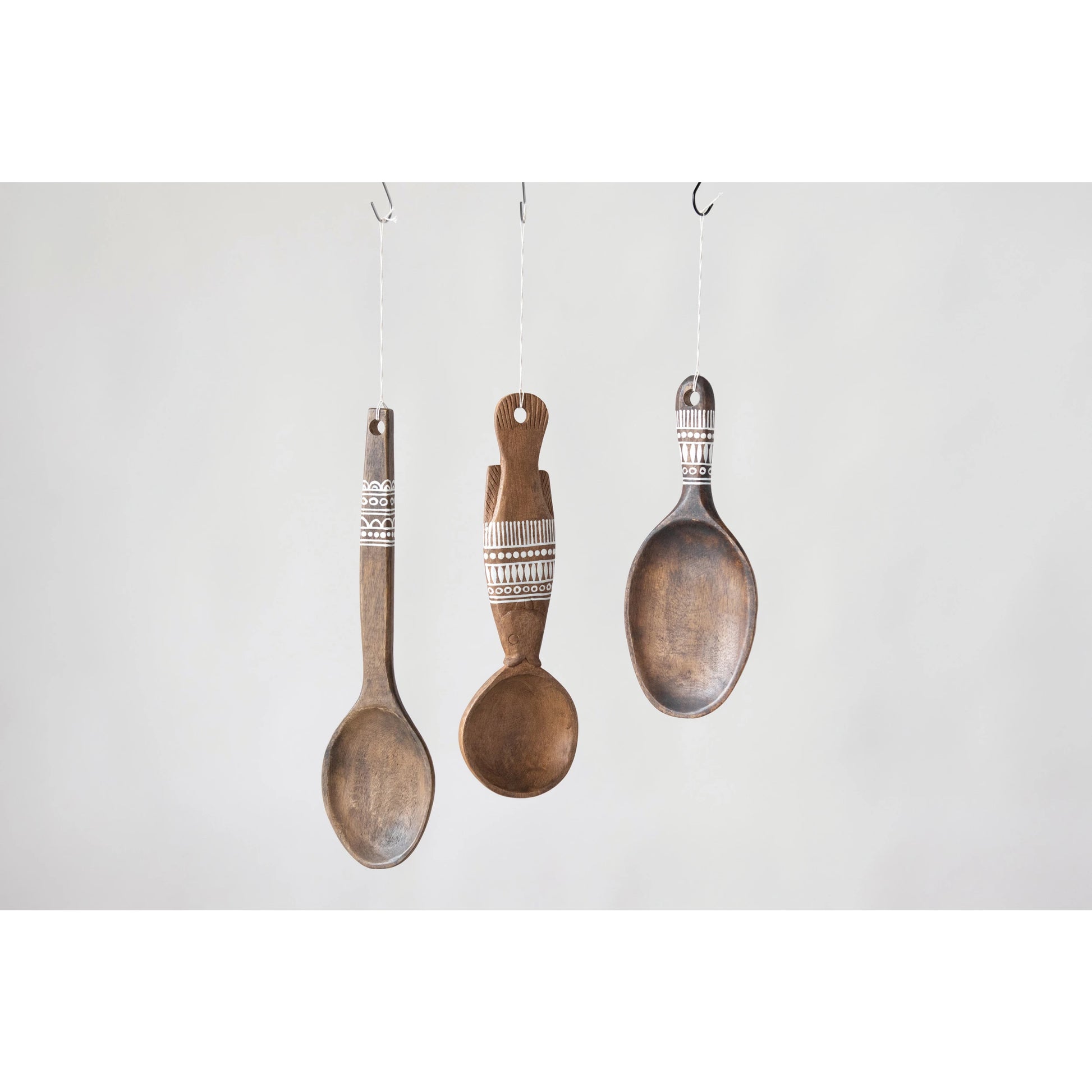 all three styles of decorative wall hanging spoons displayed hanging against a light gray background