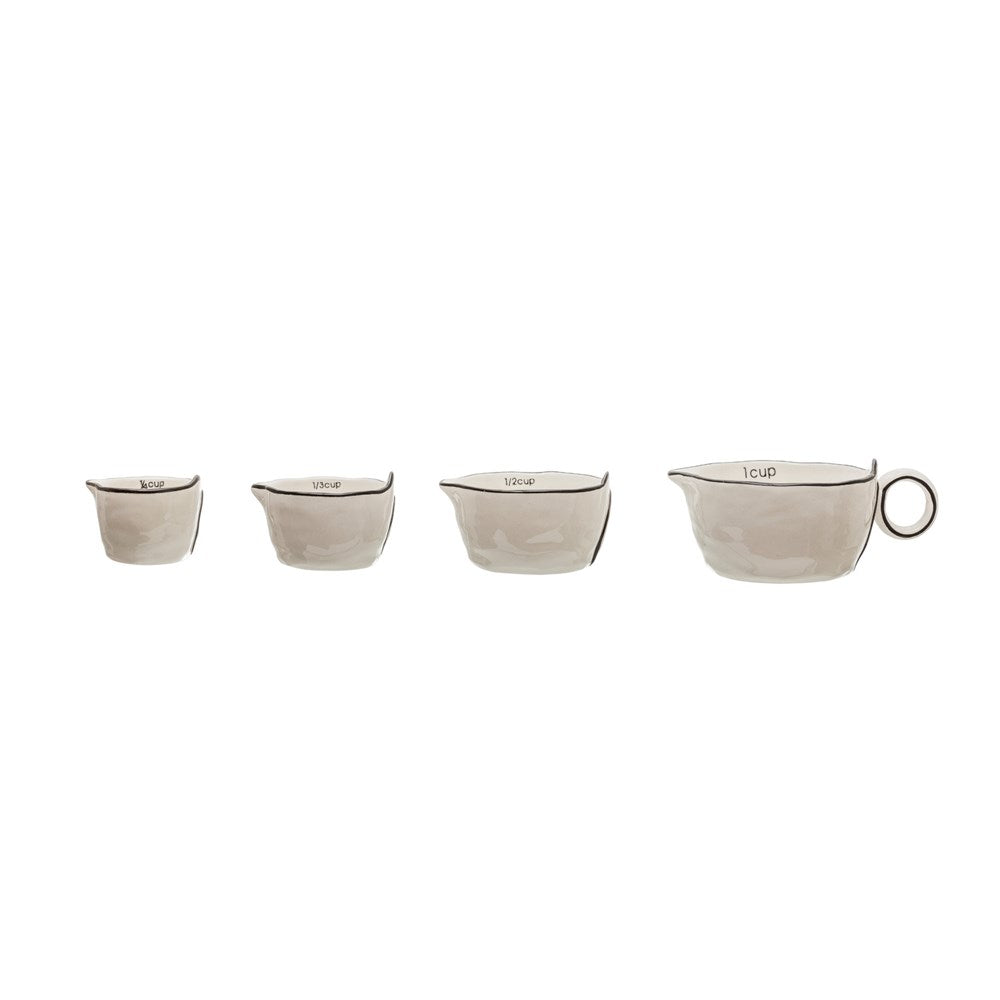 black and white measuring cups in a row on a white background.