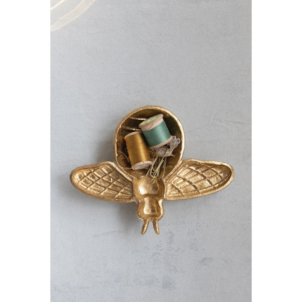 golden bee shaped dish filled with sewing notions.