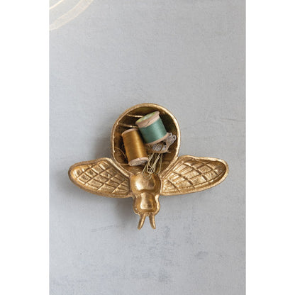 golden bee shaped dish filled with sewing notions.