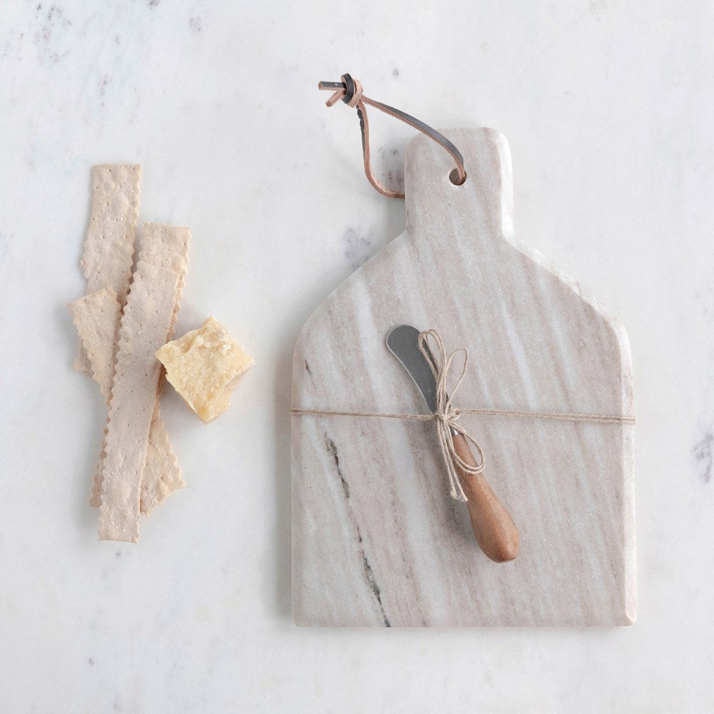 marble board with knife displayed next to thin slices of bread on a white surface