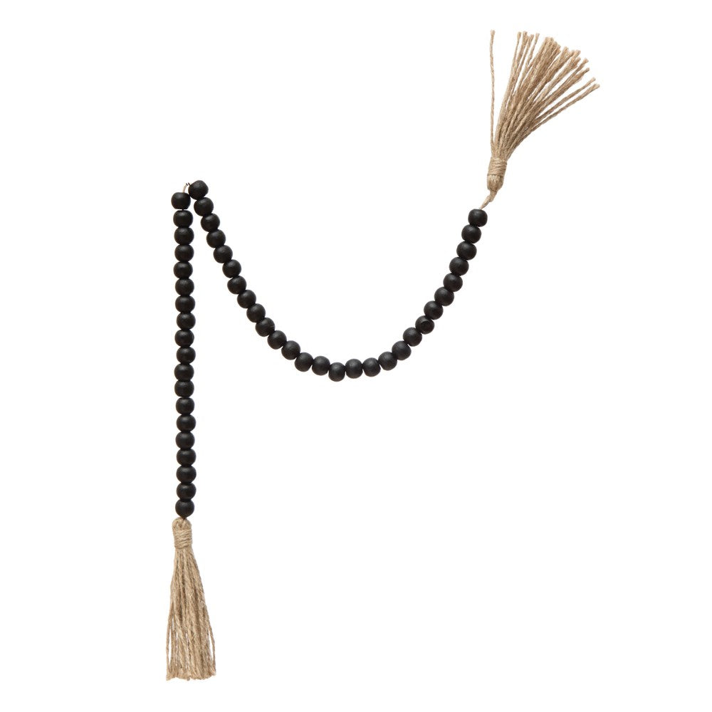 black wooden bead garland with tassels on a white background