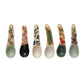 six different hand painted stoneware spoons on a white background 