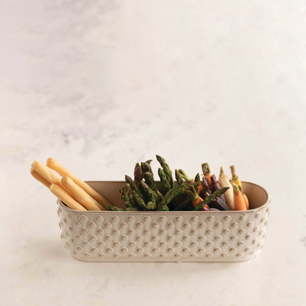 White three section dish filled with breadsticks, asparagus and carrots.