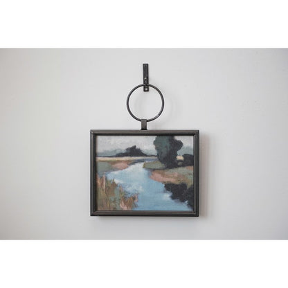 landscape art with metal frame hanging on a gray wall 