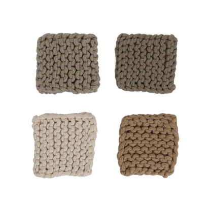 four different colored cotton crocheted coaster displayed on a white background
