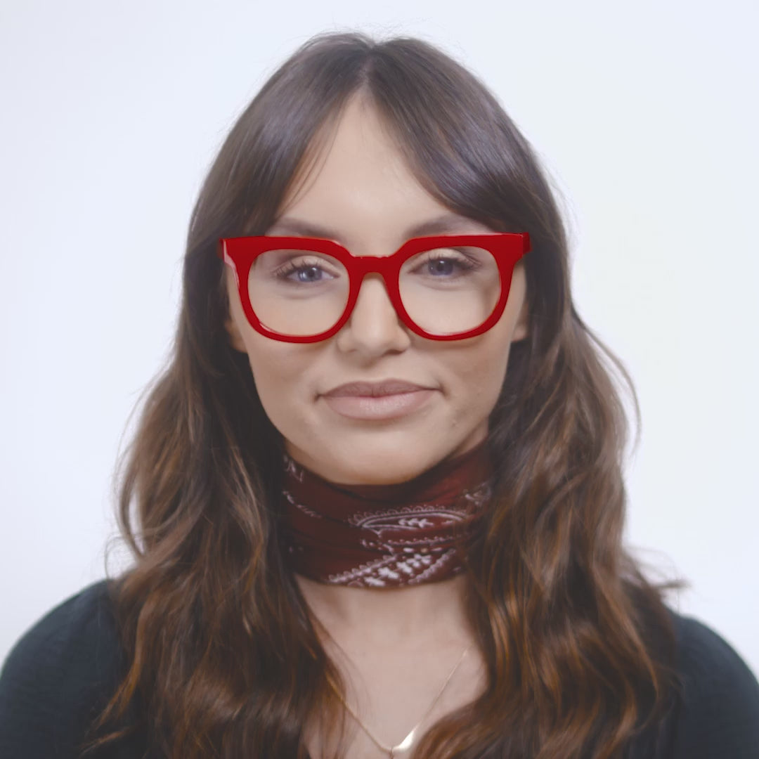 video of a woman the red harlow glasses and turning her head to show both sides against a white background
